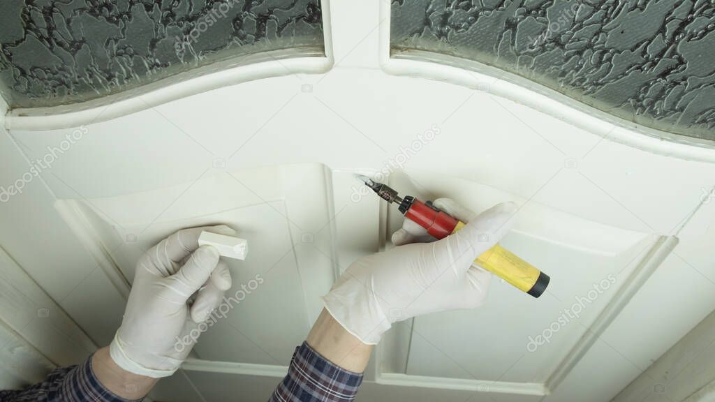 restoration of a white wood door,master sealing the scratch close-up, furniture restoration