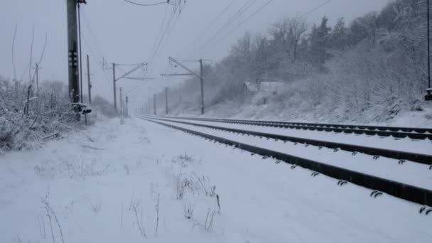 Snöfall på bakgrunden av järnvägsspår — Stockvideo