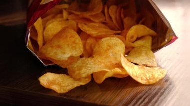 El paketten altın patates cipsi alır.