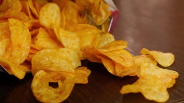 El paketten altın patates cipsi alır.