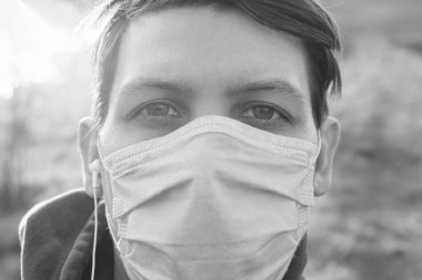 Tıbbi maske takan genç bir adamın portresi.