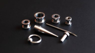 Koyu bir arka plan, kulak tünelleri, tüneller ve kulaklar ve diller için küpeler.