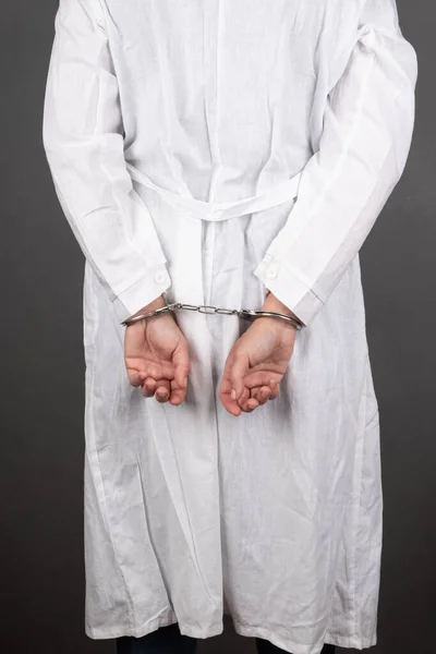 Medico in manette di fronte al muro, detenzione di un crimine medico — Foto Stock