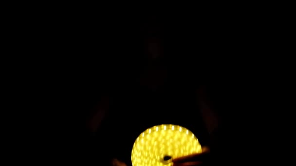 LED amarelo tira bobina iluminação decorativa na mão sobre fundo escuro — Vídeo de Stock