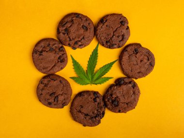 Ortasında yeşil yaprak olan bir çember kenevir kurabiyesi, tatlı marihuana yiyeceği.
