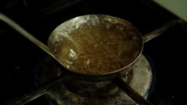 가스 스토브에 있는 열수 캐러멜로 사탕을 만든다 — 비디오