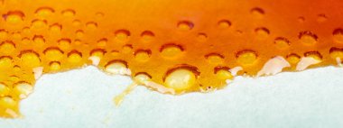 medical cannabis wax running down the paper, orange bubbles resin marijuana
