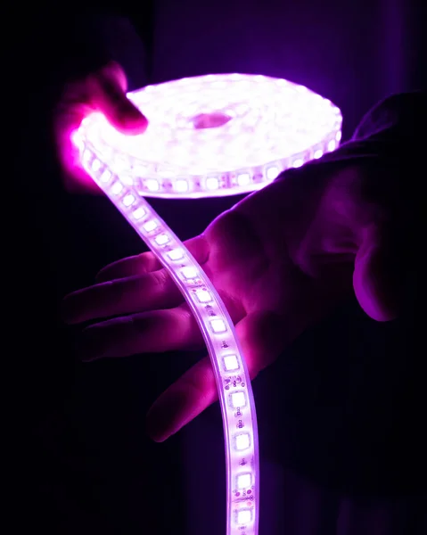 Tira de diodo led decorativa color magenta en la mano. —  Fotos de Stock