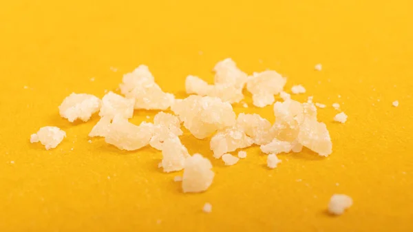 Crystal pieces wax of marijuana concentrate, cannabis dab on yellow background — Fotografia de Stock