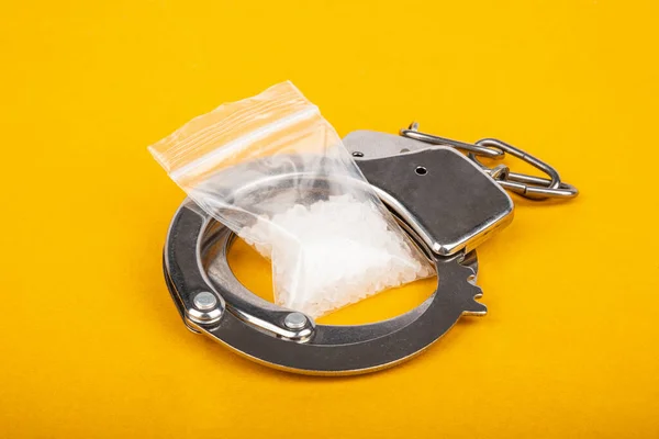Наказание за торговлю наркотиками, арест наркоторговцев наручниками и кристаллами мефедрона амфетамина — стоковое фото