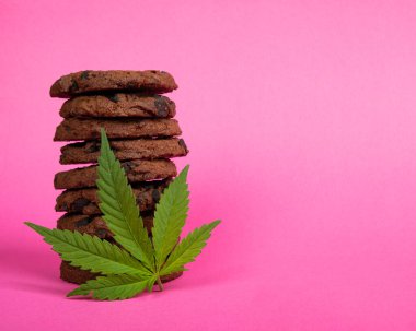 tatlı kurabiyeler ve marihuana yaprağı pembe arka planda kenevir esrarı yağı