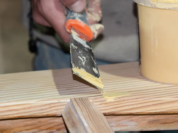 Рука с шпателем деревянные ремесла, реставрация дверей — стоковое фото