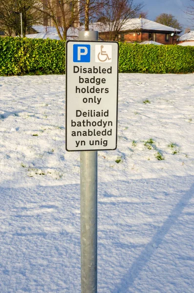 只有在雪地覆盖的停车场里 才会有一个标志标明残疾徽章持有者停车的地方 — 图库照片