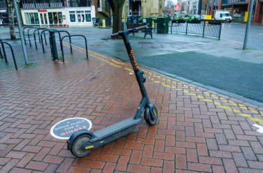 Chester; Birleşik Krallık: 29 Ocak 2021: Ginger tarafından işletilen elektrikli scooter, rutubetli bir cuma günü öğleden sonra işe alınmayı bekliyor.