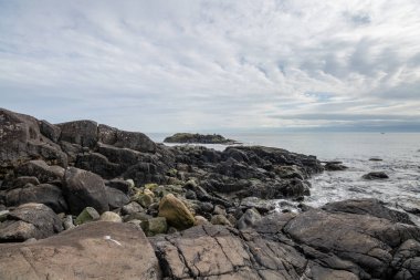 Doğu Sooke Bölgesel Parkı 'ndaki Vancouver Adası' ndan bulutlu bir günde Salish Denizi kıyısındaki kayaların görüntüsü