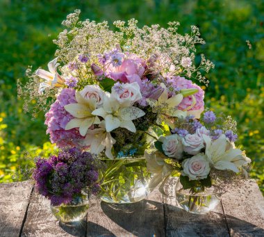 güzel yeşil arka plana sahip ahşap masaya çiçek demetleri
