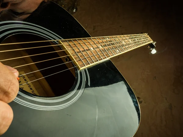 Foto de primer plano de una guitarra acústica tocada por un hombre . — Foto de Stock