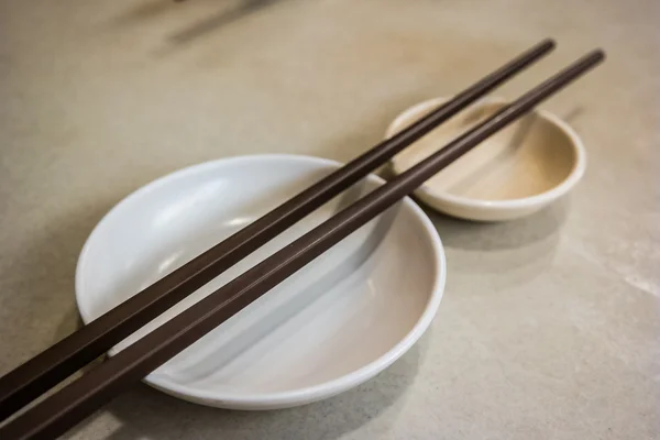 Plato vacío con palillos en la mesa . — Foto de Stock