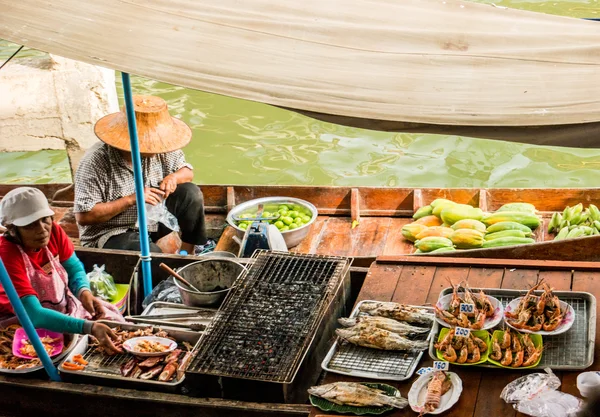 Tayland kayan bir pazarda tüccarlar tekneler.