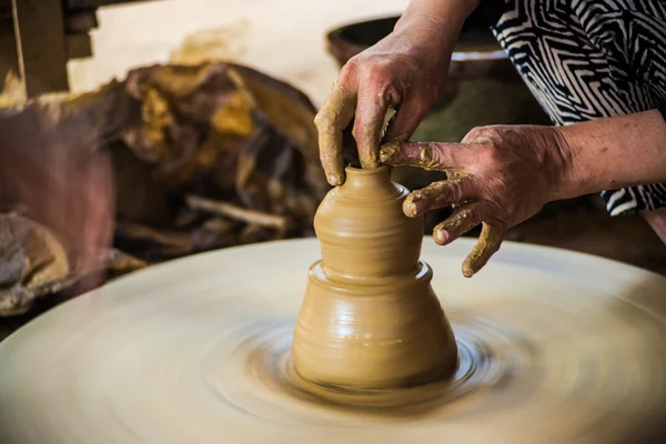 Vértes nézet a kezében egy régi ázsiai potter — Stock Fotó