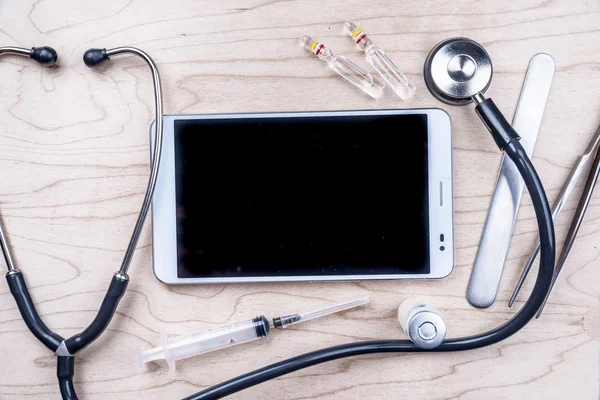 Tablet pc met medische objecten op een bureau — Stockfoto