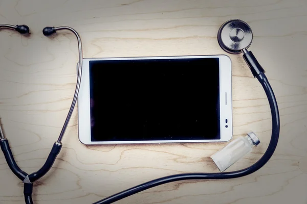 Tablette PC avec objets médicaux sur un bureau — Photo