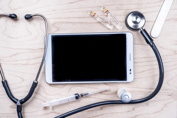 Tablette PC avec objets médicaux sur un bureau — Photo