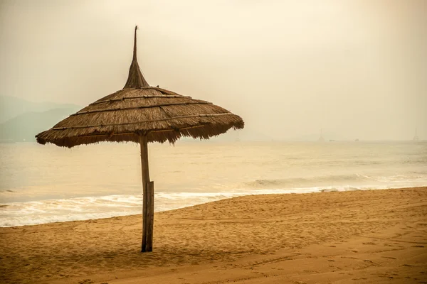 Simple scene with straw umbrella — Stock Photo, Image