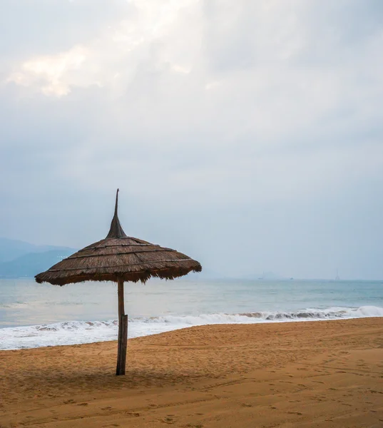 Simple scene with straw umbrella — Stock Photo, Image