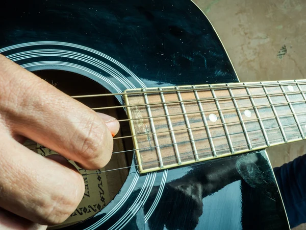 Foto de close-up de uma guitarra acústica tocada por um homem . — Fotografia de Stock