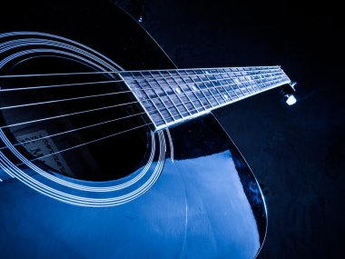 Portre fotoğraf bir adam tarafından oynanan bir akustik gitar.