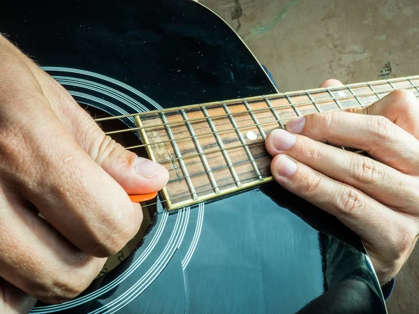 Foto de primer plano de una guitarra acústica tocada por un hombre . —  Fotos de Stock