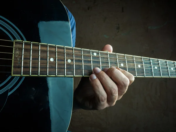 Foto in primo piano di una chitarra acustica suonata da un uomo . — Foto Stock