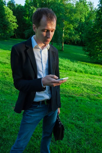 Joven hombre usando traje qith smartphone —  Fotos de Stock