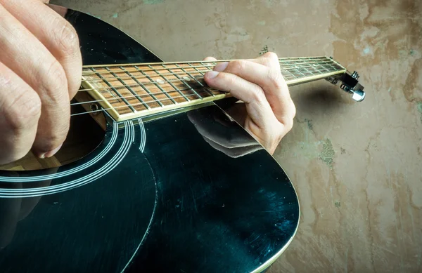 Foto in primo piano di una chitarra acustica suonata da un uomo . — Foto Stock