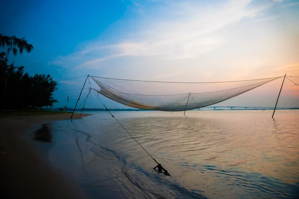 Calm scene of fishing net against purple sunset. — Stock Photo, Image