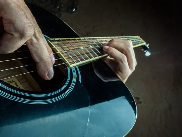 Foto de primer plano de una guitarra acústica tocada por un hombre . — Foto de Stock