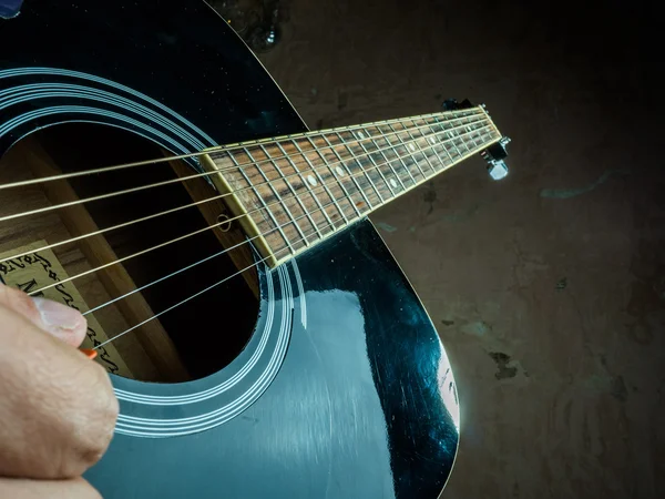 Foto de primer plano de una guitarra acústica tocada por un hombre . — Foto de Stock