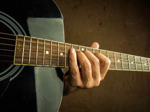 Foto de close-up de uma guitarra acústica tocada por um homem . — Fotografia de Stock