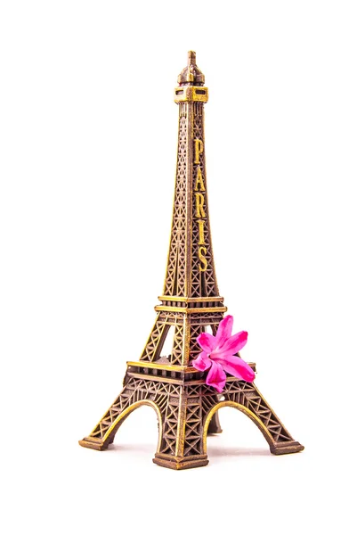 Model of little Eiffel Tower with a pink flower — Stock Photo, Image