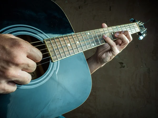 Foto de primer plano de una guitarra acústica tocada por un hombre . — Foto de Stock