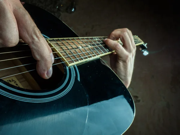 Foto in primo piano di una chitarra acustica suonata da un uomo . — Foto Stock