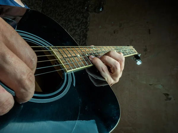 Foto de primer plano de una guitarra acústica tocada por un hombre . — Foto de Stock