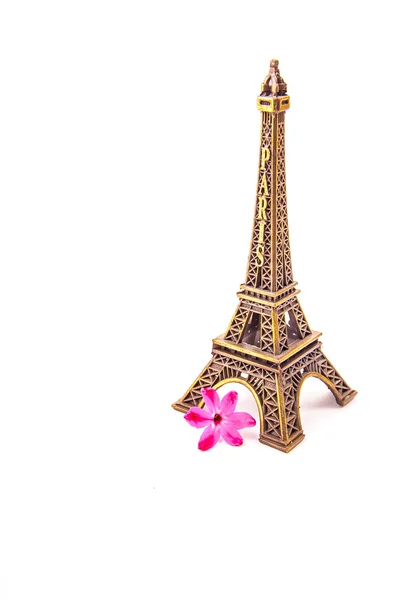 Model of little Eiffel Tower with a pink flower — Stock Photo, Image