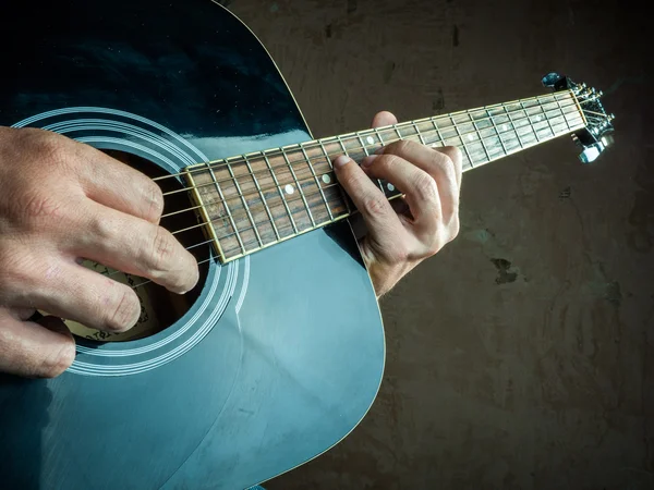 Foto de primer plano de una guitarra acústica tocada por un hombre . — Foto de Stock