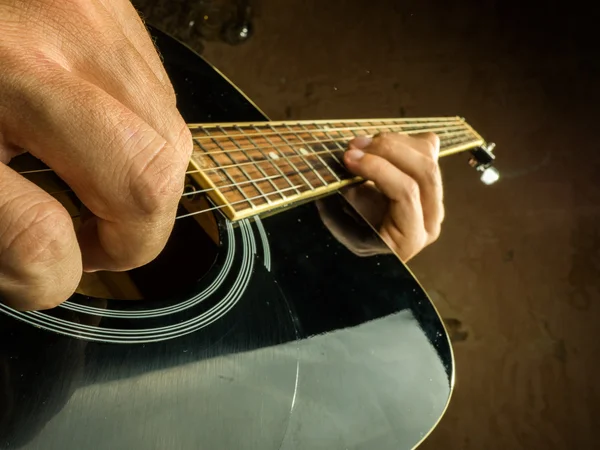 Foto de primer plano de una guitarra acústica tocada por un hombre . —  Fotos de Stock