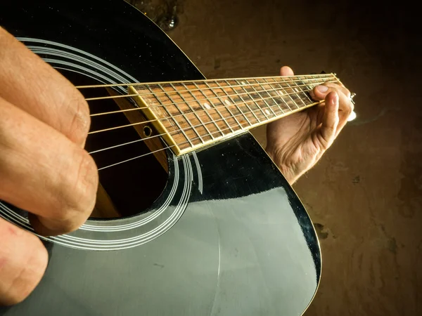 Foto de primer plano de una guitarra acústica tocada por un hombre . — Foto de Stock