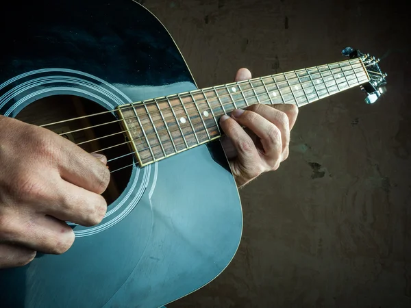 Foto de primer plano de una guitarra acústica tocada por un hombre . — Foto de Stock