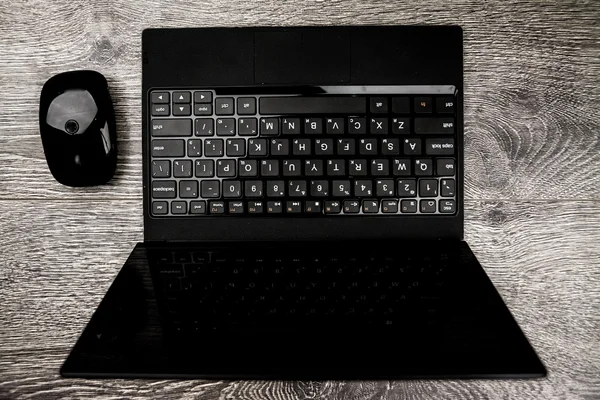Black laptop on wood — Stock Photo, Image