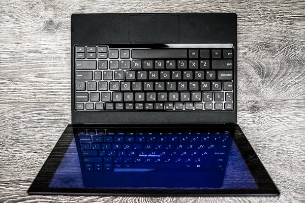 Black laptop on wood — Stock Photo, Image